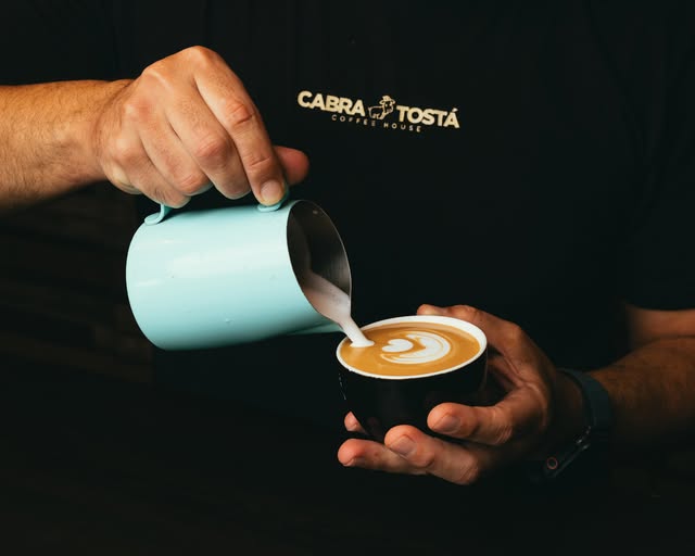 Barista sirviendo latte art en Cabra Tostá